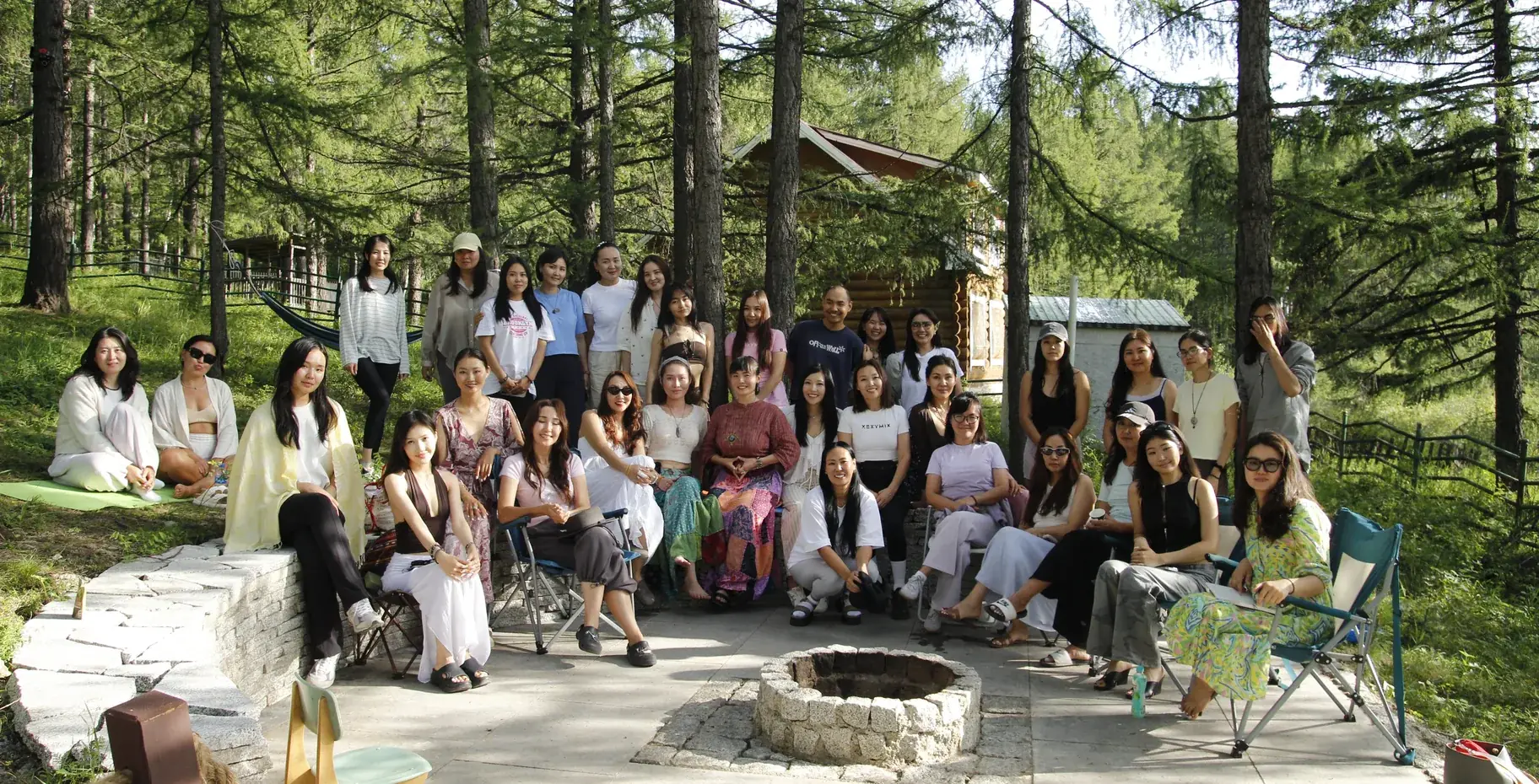 Around thirty-five members of the Greensnake community gathered around a fire pit at a forest retreat